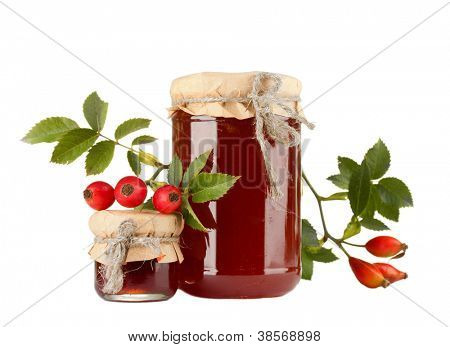 ขวดแยมกุหลาบสะโพกและสุกครบ แยกต่างหากบนพื้นสีขาว