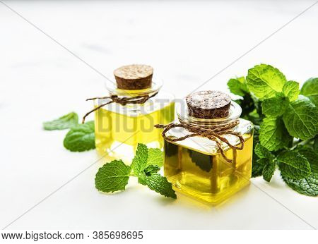 Organic Essential Mint Oil With Green Leaves
On A White  Background