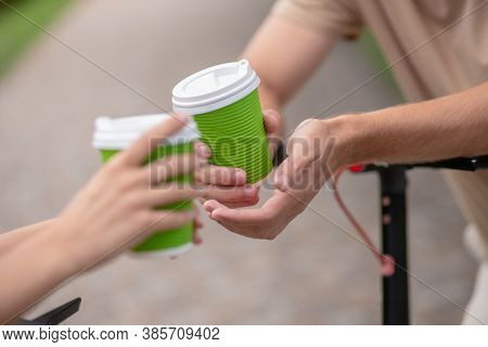 Close Up Picture Of Human Hands With Coffee Cups