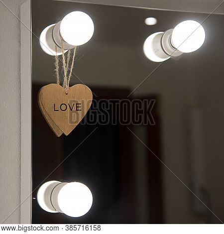 Makeup Mirror On The Wall With Lights. Beauty Salon With A Mirror With Lamps. A Wooden Heart With Th