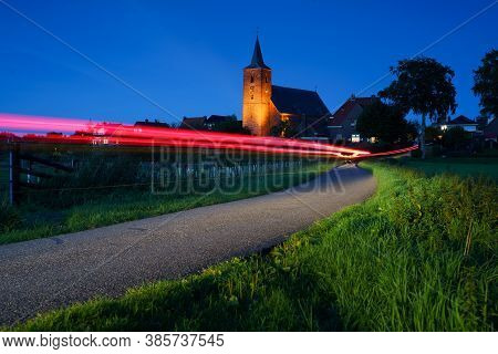 Medieval Church In The Floodplains On A Dike Of A Dutch River Landscape
