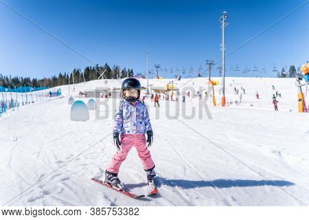 Young Happy Skier Girl Learning How To Ski On The Green Ski Zone. Young Skier Having Fun On Ski Slop