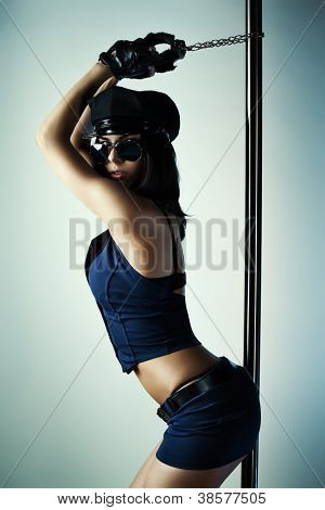 Young slim pole dance woman in abbigliamento di polizia.
