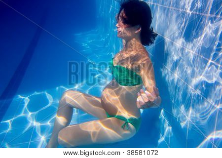 Subacquea piscina blu donna incinta bella rilassata