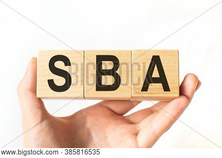 Hand Holds Wooden Cubes With Letters Sba. Business Concept Image.