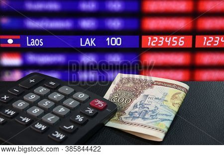 Five Hundreds Of Banknote Currency Lao Kip With Calculator On The Black Floor With Laos Nation Flag 