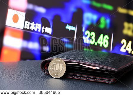 Japanese Five Hundred Yen Coins On Reverse (jpy) On Black Floor With Black Wallet And Digital Board 