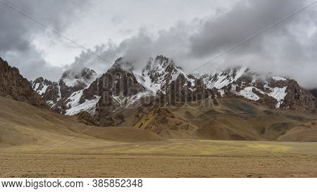 Rain, Clouds And Orange Colored Mountains With Snow At The Pamir Highway In Tajikistan Near Alichur 