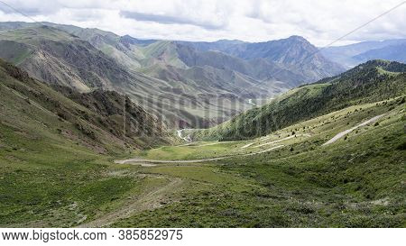 Road On The Song Kol Pass In Kyrgyzstan With Mountains And Hills.