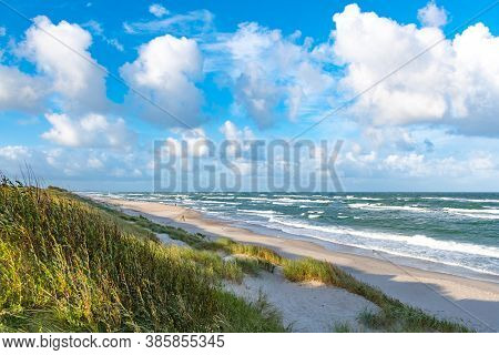 Rough Sea With Waves In Autumn Or Winter, Sandy Beach And Dunes With Reeds And Dry Grass In The Morn