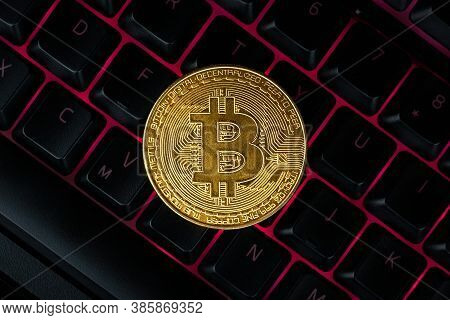 Bitcoin On Compuer Keyboard In Background, Symbol Of Electronic Virtual Money And Mining Cryptocurre