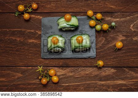 Appetizer Of Green Cucumbers And Cheese Vegetable Rolls With Yellow Cherry Tomatoes, Canapes On An A