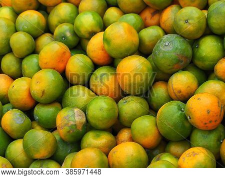 Pile Of Tangerines For Sale In The Market. Full Frame Photo. Concept Of Fruits Healthy