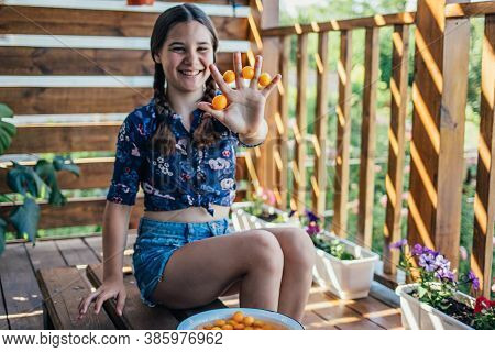 Young Girl Holding Yellow Fruits In Her Hands, Healthy Breakfast, Snack. Selective Focus