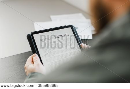 Close Up Businessman Reading Elecronic Rental Agreement On Tablet.