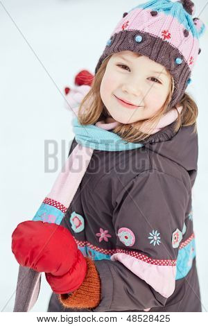 Portret van meisje dragen van winter kleding tegen besneeuwde achtergrond