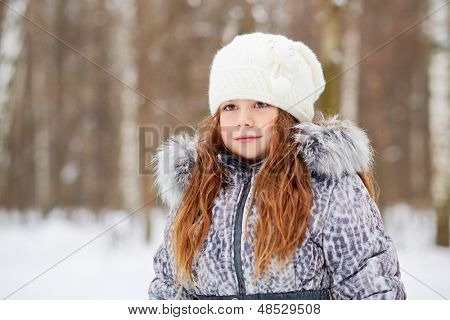 Retrato de medio cuerpo de la chica vestida con chaqueta con cuello de piel y sombrero de punto blanco parado en Victoria
