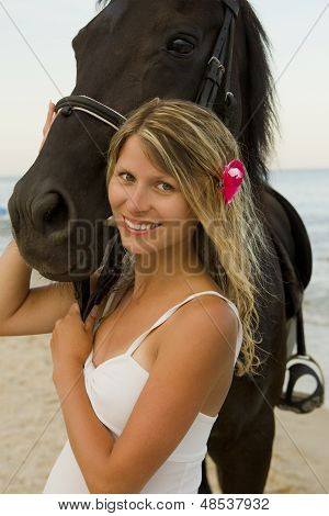 Pige med en hest ved havet