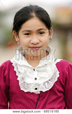 VANG VIENG, LAOS, MARCH 18, 2011: Portrait of a Laotian little girl wearing traditional clothes in the village of Vang Vieng in Laos.