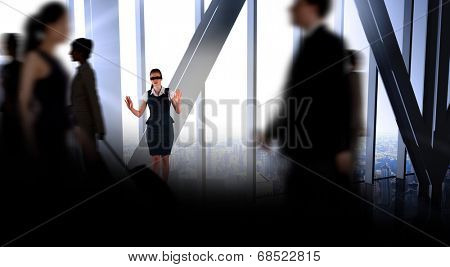 Redhead businesswoman in a blindfold against room with large window looking on city