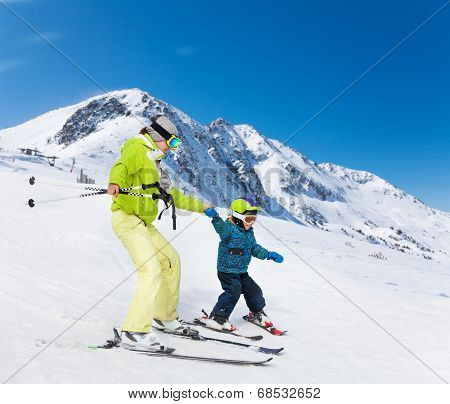 Instructor and kid skiing down the mountain