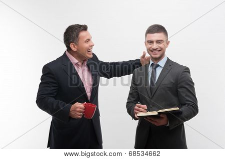 Senior and junior business people discuss something