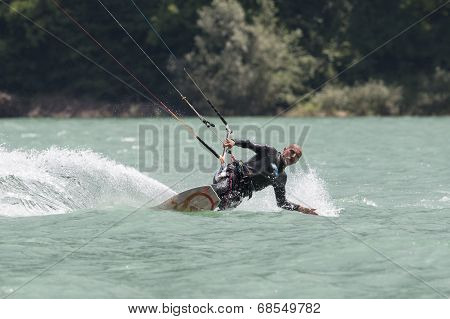 Professional  Kitesurfer Jumps Over The Water During Training On Lake Of Santa Croce