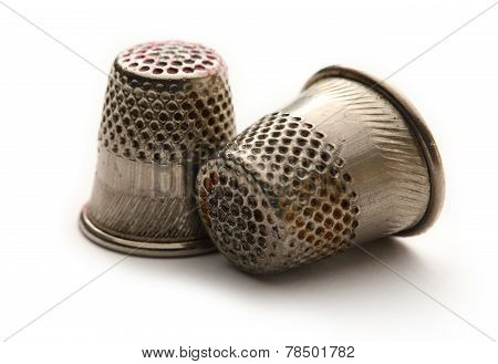 Two Metal Sewing Thimbles On White