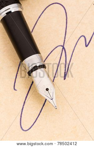 a signature and a fountain pen on yellow paper. symbolic photo for contract, testament and graphology