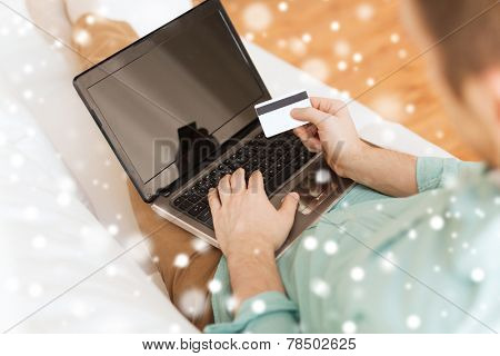 technology, shopping, banking, home and people concept - close up of man with laptop computer and credit card at home