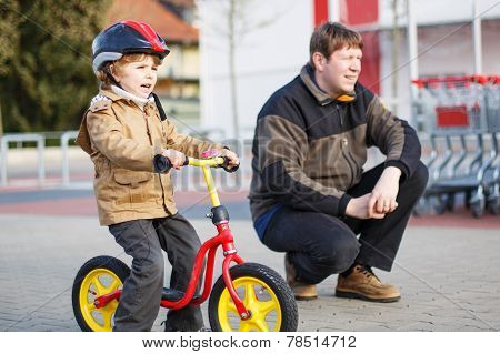 Little Toddler Boy With Bicycle And His Father In The City
