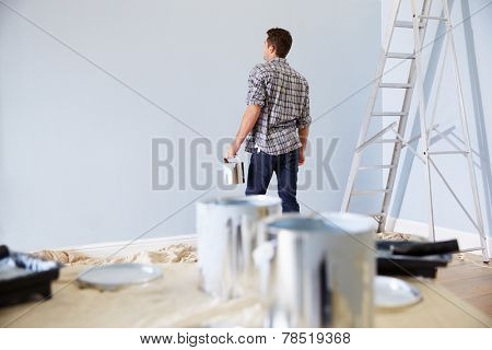 Man Decorating Nursery For New Baby