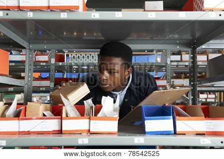 Factory Worker With Clipboard In Storeroom