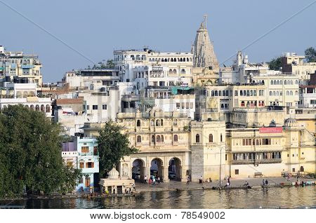 indian people enjoying beautiful view of Pichola lake and palaces at embankment of Udaipur city
