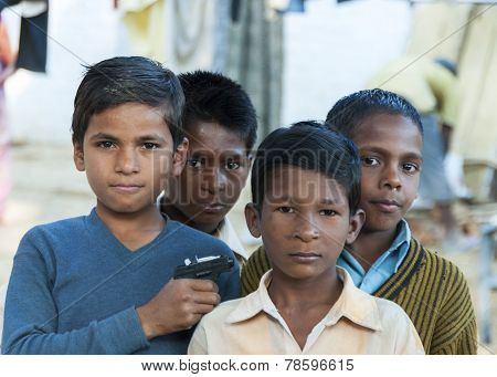 Four Boys, One Holding Toy Gun.