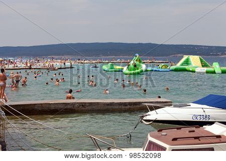 SELCE, CROATIA - JULY 24, 2015: People swimming and sunbathing on the Selce beach