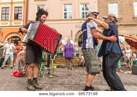 KRAKOW, POLAND - JUL 12, 2015: Participants at the annually (July 9-12) 28th International Festival of Street Theatres - Orchestre International du Vetex (Belgium/France) in the Main Square of Krakow.