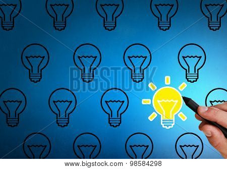 Close up of hand darwing light bulb with marker