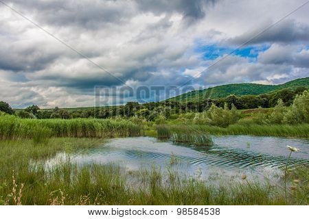 Clouds Over Hills Green Grass And Water