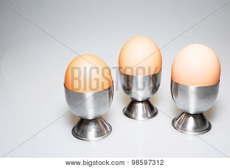 Three Eggs In The Stands On Isolated White