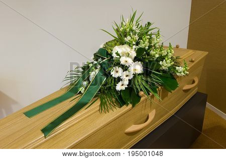 A coffin with a flower arrangement in a morgue