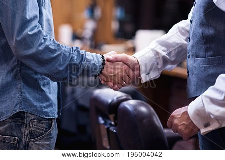 Greeting gesture. Close up of a male handshake being done by nice pleasant men while greeting each other