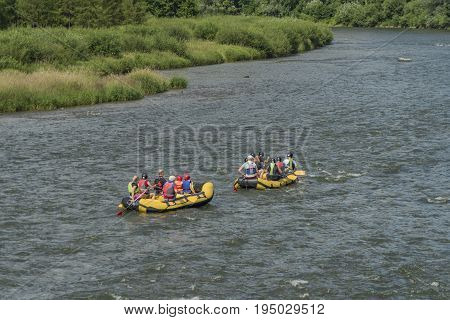 Boats on river Dunajec after rain with blue sky and white clouds