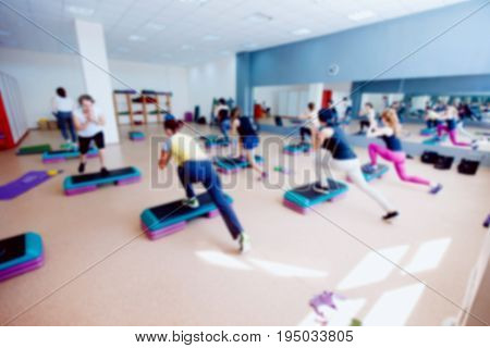 Blurred background of people group of girls playing in yoga and fitness,crossfit in the gym.