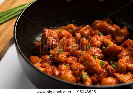 Gobi Manchurian dry - Popular street food of India made of cauliflower florets in a frying pan, selective focus