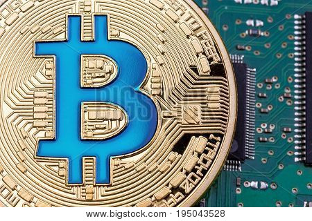 Golden Bitcoin currency on a circuit board background. High resolution photo.