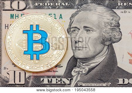 Golden cryptocurrency blue bitcoin on ten dollar banknote background. High resolution photo.
