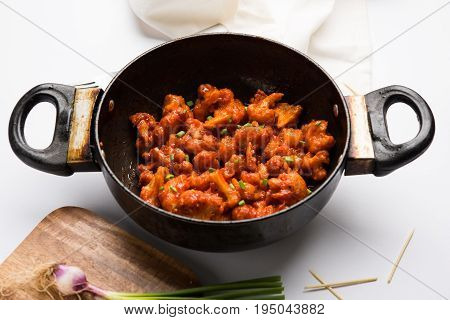 Gobi Manchurian dry - Popular street food of India made of cauliflower florets in a frying pan, selective focus