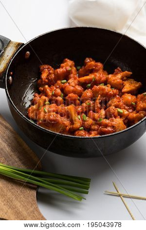 Gobi Manchurian dry - Popular street food of India made of cauliflower florets in a frying pan, selective focus