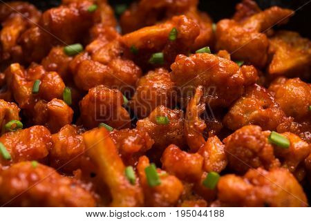 Gobi Manchurian dry - Popular street food of India made of cauliflower florets in a frying pan, selective focus